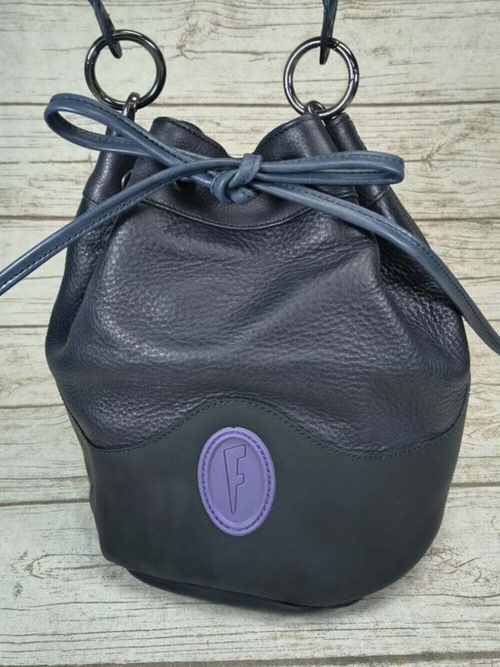 John Fluevog Navy Pebbled Leather Drawstring Bucket Bag Purple F Logo
